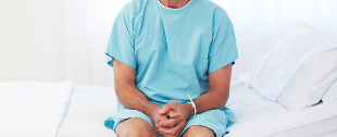 A man is sitting in a hospital bed